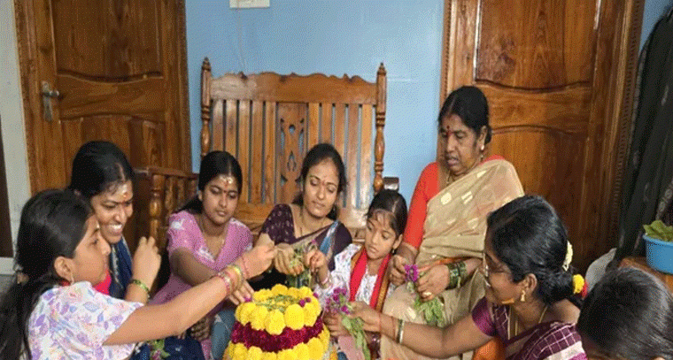 కుటుంబ సమేతంగా సద్దుల బతుకమ్మను పేరుస్తున్న మహిళలు